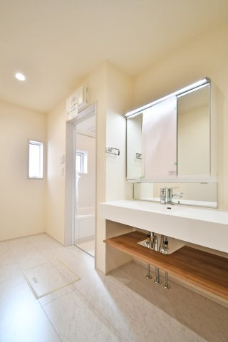 上尾市原市全1棟　1号棟の独立洗面台|空間を美しく彩るフルフラットカウンターの広々洗面所。足元がオープンな造作風デザインは掃除もしやすく、清潔感をキープ。横には便利な収納も備え、毎朝の身支度をスムーズで贅沢な時間に変えます。