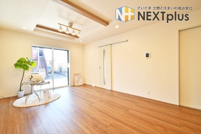 北足立郡伊奈町中央4丁目全2棟　2号棟の居間・リビング|南道路に面した明るいリビングは、折上天井を採用し開放感溢れる空間を演出 。17帖の広々としたLDKは、家族が自然と集まる心地よい住まいの中心になります 。木の温もりを感じるデザインです。