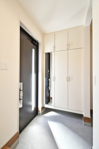 北足立郡伊奈町中央4丁目全2棟　2号棟の玄関|大容量のシューズボックスを備えた玄関。家族全員の靴をすっきり収納でき、常に清潔感のある空間を保てます。姿見付きでお出かけ前の身だしなみチェックもスムーズ。明るく開放感のある家の顔にふさわしい空間です。