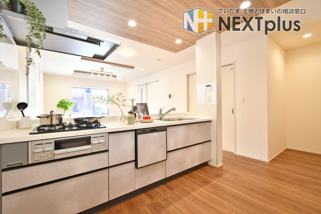 北足立郡伊奈町中央4丁目全2棟　2号棟のキッチン|会話が弾む対面キッチン。食洗機付で家事時間を短縮し、奥には便利なパントリーも完備しました。折上天井が空間を彩るリビングを見渡しながら、家族との温かな時間を育める機能的な設計です。