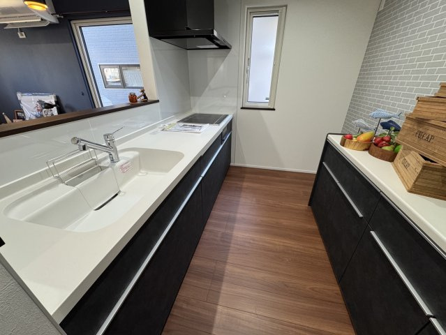 釧路市愛国東1丁目Kospaモデル▽家事動線と収納力が自慢の高性能な家のキッチン|対面式で会話も弾む。シックな黒のパネルが映える洗練空間。