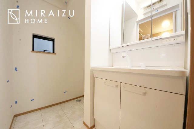 【洗面所】 | 洗濯機置き場と脱衣スペースもしっかりと確保されている洗面室、洗面コーナーは、窓から陽も差し明るく開放的な造りです。家事導線も良いので洗濯物やお湯はりもストレスフリーに毎日家事を楽しめそうです。