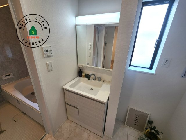 福岡市東区名島3丁目第1-1棟(1号棟)の独立洗面台|毎日使うものだから清潔な空間を保ちたい水回り。洗面にはそんな願いを解消させてくれる収納アイデアが満載です。三面鏡の裏側にはキャビネットが現れ小物から背の高い物まで収納できます。