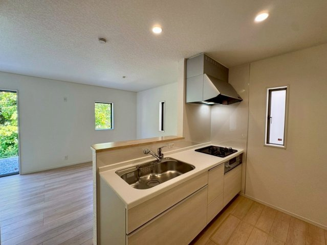 クレイドルガーデン南城市佐敷佐敷 第1・1号棟のキッチン|会話の弾む対面式のシステムキッチン・換気窓＆床下収納付き