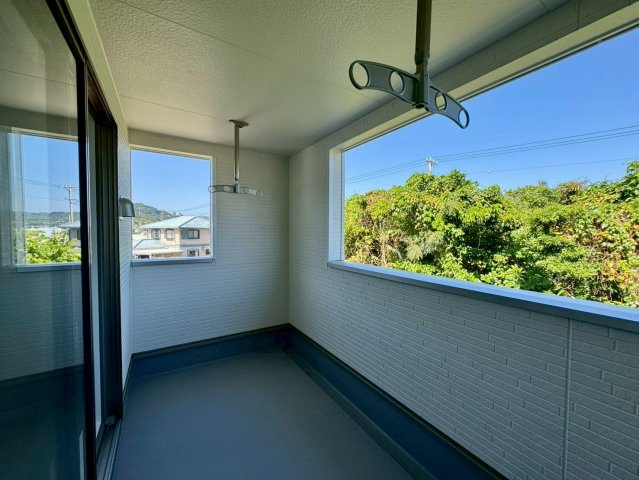 クレイドルガーデン南城市佐敷佐敷 第1・1号棟のバルコニー|急な雨も安心♪広々二面ルーフバルコニー／緑豊かな周辺環境