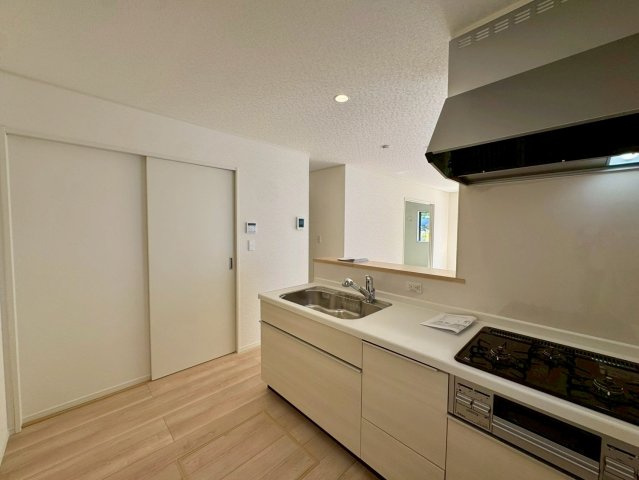 クレイドルガーデン南城市佐敷佐敷 第1・２号棟のキッチン|キッチン脇には洗面室がある、家事動線に優れた水回り集中設計