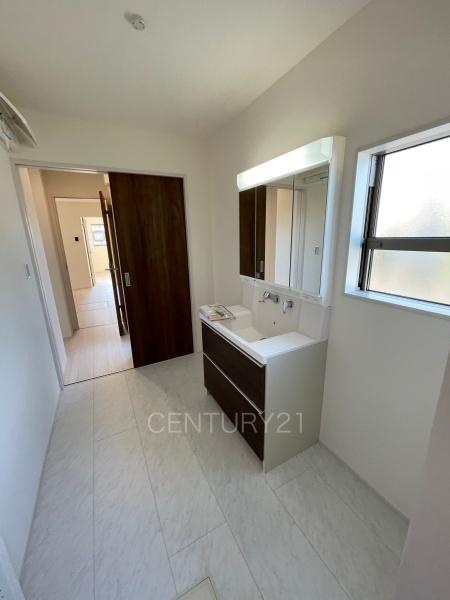 第１吉岡町漆原１号棟の独立洗面台|三面鏡付きの洗面台には鏡の裏に収納があり、すっきり片付けられます。
洗髪も可能な伸縮機能つきシャワーヘッドです。