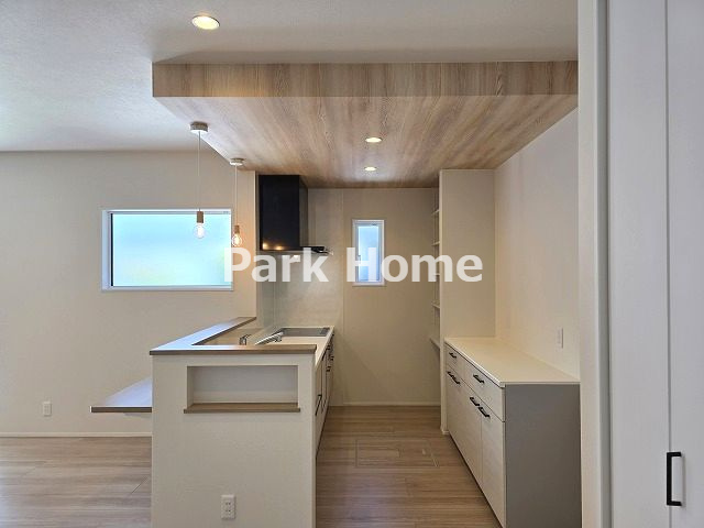 高知市介良乙　新築戸建てのキッチン|手入れのしやすいIH仕様のシステムキッチンです。リビングにいる家族の様子を見守りながら調理ができ、手際良く料理を進められます。スライド式の収納スペースは大きなお鍋の出し入れも快適です。