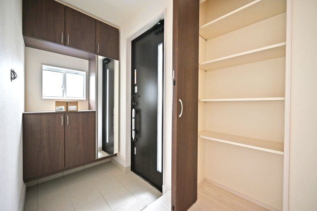 ブルーミングガーデン堀池1丁目新築一戸建│3LDK+駐車2台可(車種制限有)の玄関|1階玄関をホール側から撮影した内観写真です。 シンプルな玄関扉にシューズボックス、小窓を配置したオーソドックスな玄関です。可動棚収納も設けられており、豊富な収納量です。