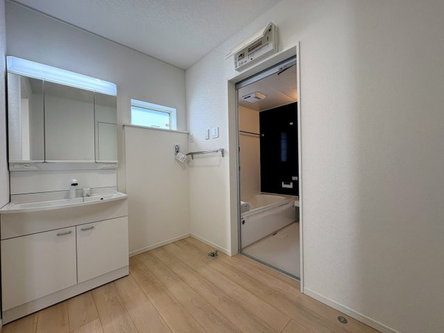 クレイドルガーデン糸満市喜屋武 第６・２号棟の独立洗面台|ハンドシャワー付き洗面化粧台＆洗濯機置場から浴室への動線