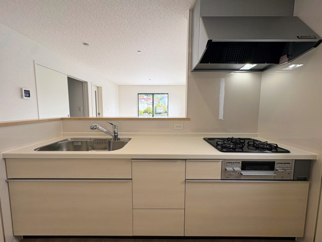 クレイドルガーデン糸満市喜屋武 第６・３号棟のキッチン|コミュニケーションの取りやすい対面式のキッチン／リビングの眺め