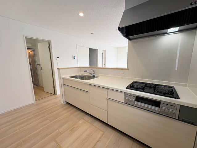 クレイドルガーデン糸満市喜屋武 第６・３号棟のキッチン|キッチンの脇には洗面室があり、家事が捗る水回り集中設計◎