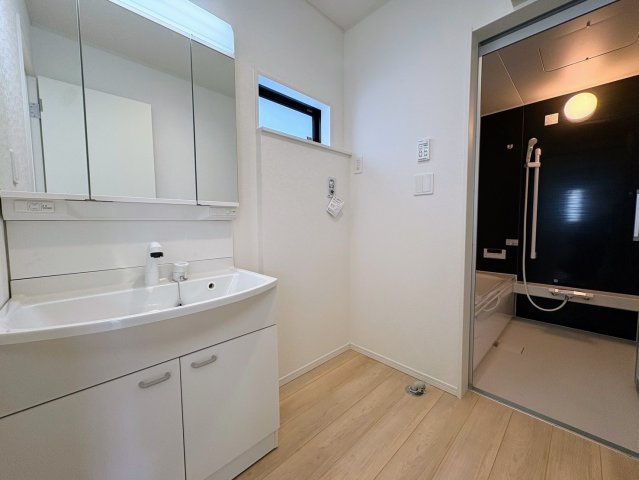 クレイドルガーデン糸満市喜屋武 第６・３号棟の独立洗面台|ハンドシャワー付き洗面化粧台＆洗濯機置場から浴室への動線