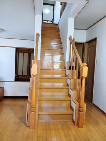 売中古戸建　中央区高丘東四丁目の居間・リビング|リビングを通る動線なので、、自然と家族との会話が生まれます。階段下収納、手すりの下にも小物入れあります。