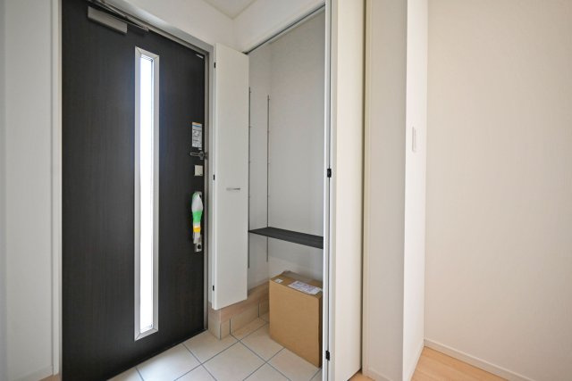 クレイドルガーデン伊丹市荻野西1丁目新築一戸建て│3SLDK+駐車駐輪の玄関|1階玄関を廊下側から撮影した内観写真です。 収納庫内は可動棚になっているので靴のサイズに合わせて棚の高さを変更できます。