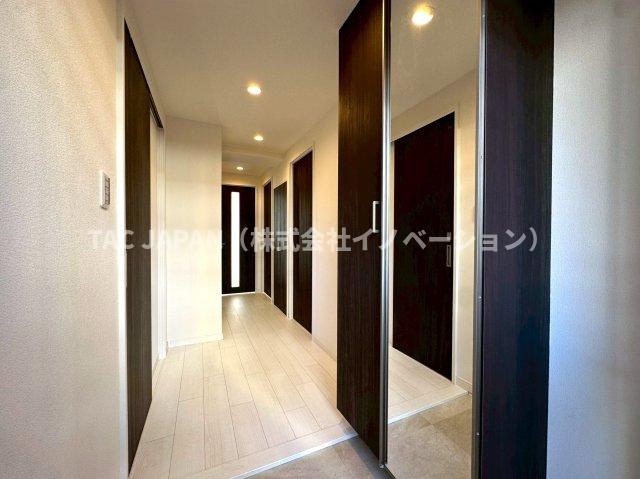 グリーンパーク王子の玄関|日頃からスッキリ使いたい玄関スペースには天井まで届く鏡付きの大型シューズボックスと廊下収納を完備。明るく清潔感ある上質な玄関を創造しています。