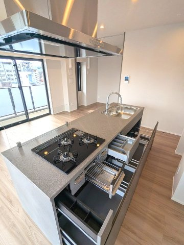 SEASON FLATS浅草六丁目の設備|グリル付ガス3口システムカウンターアイランドキッチン、奥まで収納しやすいスライド式の収納、瀟洒でお手入れ楽なガラストップコンロです