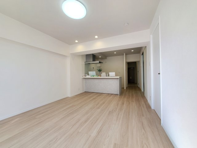 三郷　スカイマンションの居間・リビング|柔らかな色合いのフローリングと清潔感の溢れるクロスが明るい空間を創り出しているリビングダイニング