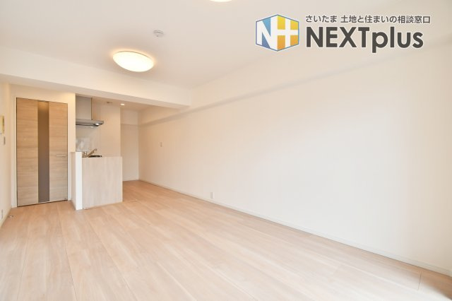 洋伸大宮マンションの居間・リビング|令和8年1月完工のフルリノベーション。13.1帖の広々としたLDKは、ナチュラルな木目調の床が心地よい開放的な空間です。対面式キッチンからはリビング全体が見渡せ、家族の会話も弾む温かな住まいです。