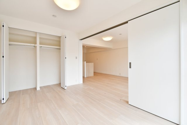 洋伸大宮マンションの洋室|ライフスタイルに寄り添う大容量クローゼット。壁一面の収納で、お部屋を常にスッキリ保てます。引き戸を開ければ約19.4帖の大空間として活用可能。家族の成長や用途に合わせて間取りを柔軟に変えられます。