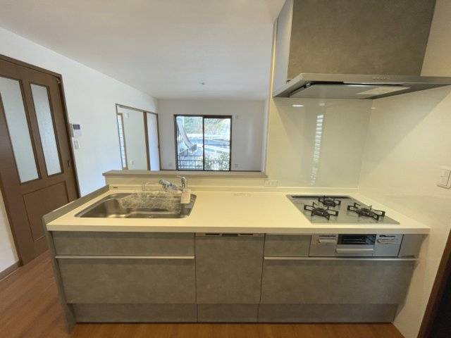 矢野南5丁目　一戸建てのキッチン|料理が映える白い天板と視線の抜けで明るいキッチンは食洗機付き。勝手口があり買い物帰りもスムーズです。