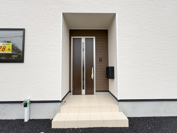 細第1-2号棟のその他|シンプルながらも落ち着いた雰囲気の玄関ドアが印象的です。引き締まったアクセントカラーが外観を引き立てます。玄関アプローチには段差がありすっきりとしたデザインです。
