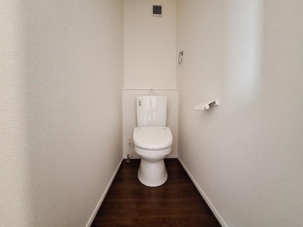 上田町3丁目1期1号棟のトイレ|落ち着いた雰囲気の内装で清潔感のあるトイレです。シンプルなデザインが空間をすっきりと見せています。窓からの採光も感じられる明るい印象です。ペーパーホルダーやタオル掛けも設置されています。