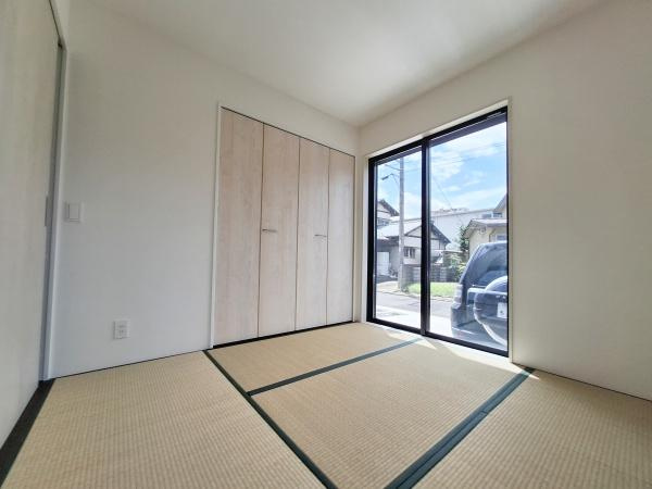 上田町3丁目1期1号棟の和室|大きな窓から明るい日差しが差し込む和室です。シンプルな内装が部屋全体をすっきりとした印象にしています。収納スペースが備え付けられておりさまざまな用途に対応できます。畳の上でゆったり過ごせる空間です。