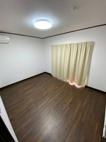 松伏町グループホームOC物件 軽量鉄骨造・一戸建の洋室|木目調フロアにエアコン完備。カーテンレール設置済の個室。
