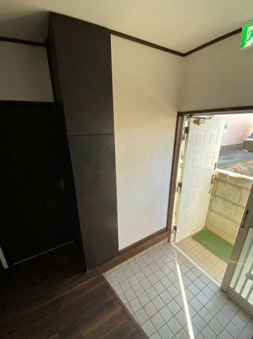 松伏町グループホームOC物件 軽量鉄骨造・一戸建の玄関|姿見付きの天井高シューズボックス。タイル貼りの玄関床。