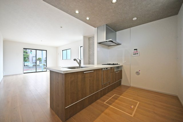 テラシエ荻野3丁目新築一戸建て│4LDK+駐車駐輪のキッチン|1階LDKをキッチン越しに撮影した現地内観写真です。 広くて使いやすいキッチンは折り下げ天井を採用しており、 オシャレな空間に仕上がりました。