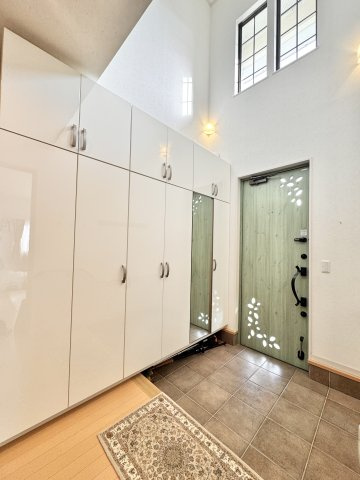 浜名区引佐町井伊谷　中古戸建ての玄関|玄関には大容量のシューズクローゼット付き！いつでも清潔な玄関をキープできます！姿見付きで、お出かけ前の身だしなみチェックに便利ですね♪吹き抜けもあり明るい空間です♪