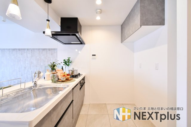 ベルヴィル大宮A棟のキッチン|料理中も家族と繋がれる対面キッチン。食洗機付きのシステムへ新規交換済みです。空間を彩るペンダントライトや大容量の吊戸棚が、家事時間を優雅でスマートなひとときへ変えます。