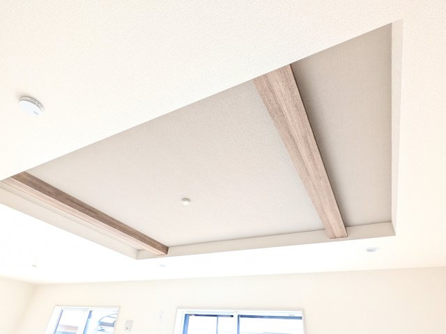 土浦市天川2丁目6期　新築戸建の居間・リビング|木目調のアクセントがおしゃれな折り上げ天井。
空間に奥行きと広がりをもたらす、デザイン性の高いリビングです。