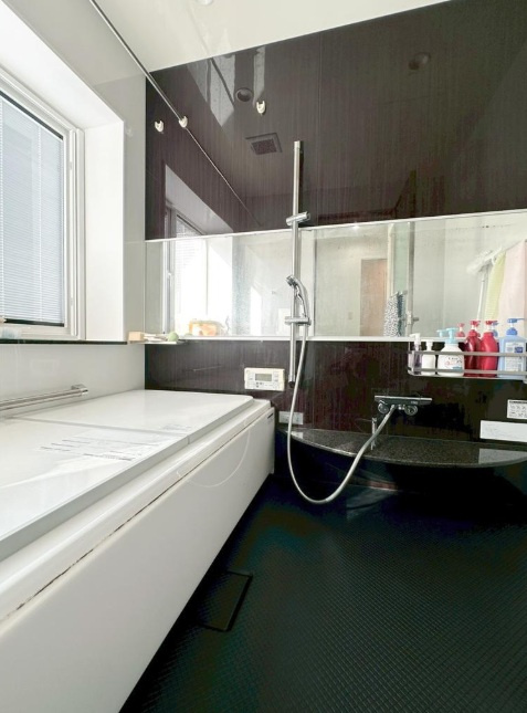 山手台7丁目の浴室|落ち着いた色合いのアクセントクロスが浴室を引き締め、シンプルな中にもデザイン性をプラス。バスタイムが楽しくなる空間設計です。