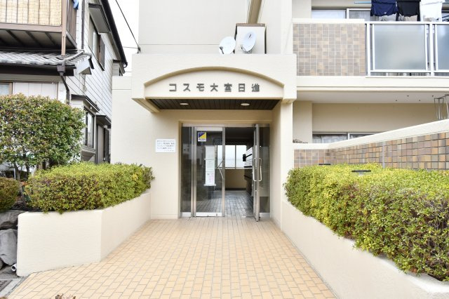 コスモ大宮日進のエントランス|明るく開放的なエントランスアプローチが、住まう人を優しく迎えます。令和8年1月に室内建具や下足入を一新し、帰宅のたびに心地よさを実感できる住空間へ。駅徒歩5分の利便性と安らぎが共存する住まいです。