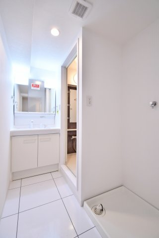 コスモ大宮日進の独立洗面台|白で統一された清潔感ある洗面室。三面鏡タイプの独立洗面化粧台は、鏡裏収納付きで小物をスッキリ整理できます。洗濯機置場も隣接し、家事動線に優れた使い勝手の良いレイアウトです。