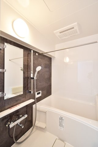 コスモ大宮日進の浴室|木目調パネルが落ち着いた雰囲気を醸し出すユニットバス。新規交換済みで、追い焚き機能や浴室乾燥暖房機など設備が充実。一日の疲れを癒やすリラックスタイムを約束します。