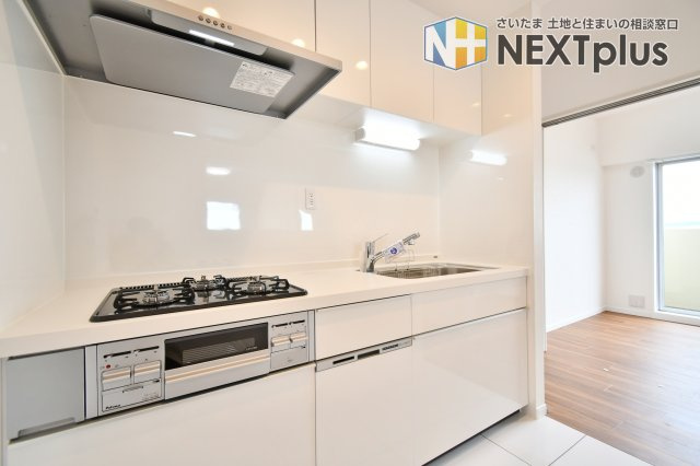 コスモ大宮日進のキッチン|新規交換されたシステムキッチンは、家事の時間を短縮するビルトイン食洗機付き。3口ガスコンロで同時調理もスムーズ。白を基調としたデザインが、空間をより明るく広々と見せてくれます。