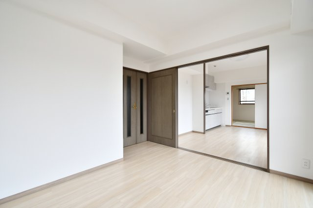 ライオンズマンション大宮大和田第2の洋室|洋室①：引き戸を開放すれば、ダイニングまで続く広々とした一体空間に。用途に合わせて柔軟に空間を仕切れるのが魅力です。角部屋ならではの多面採光で、住まい全体が明るい光に包まれます。