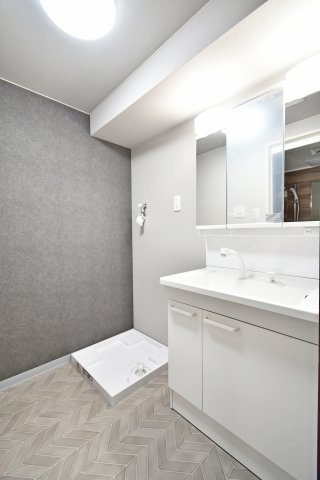 ライオンズマンション大宮大和田第2の独立洗面台|洗面化粧台も新規交換済み。三面鏡裏の収納やシャワーヘッドなど、忙しい朝に嬉しい機能が満載です。グレーの壁紙が映える清潔感ある空間で、気持ちの良い一日のスタートを。