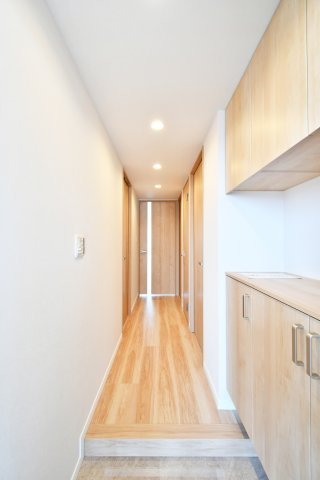 大宮パーク・ホームズのキッチン|料理中も家族やペットを見守れる対面キッチン。新規交換予定のシステムキッチンには、忙しい共働き世帯を助ける食洗機付き。木目調の美しいパネルが、毎日の家事を楽しく彩ります 。