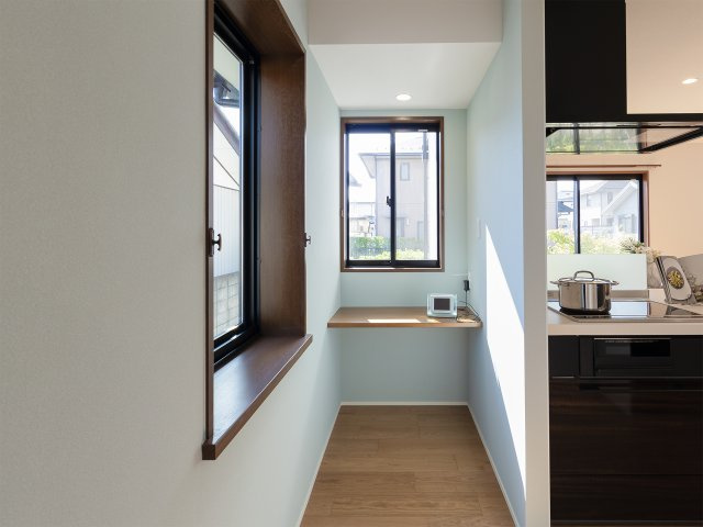 福島市笹谷のキッチン|キッチン横に窓付きカウンター。家事の合間の休憩や在宅ワークに最適な、明るい「自分時間」の特等席。