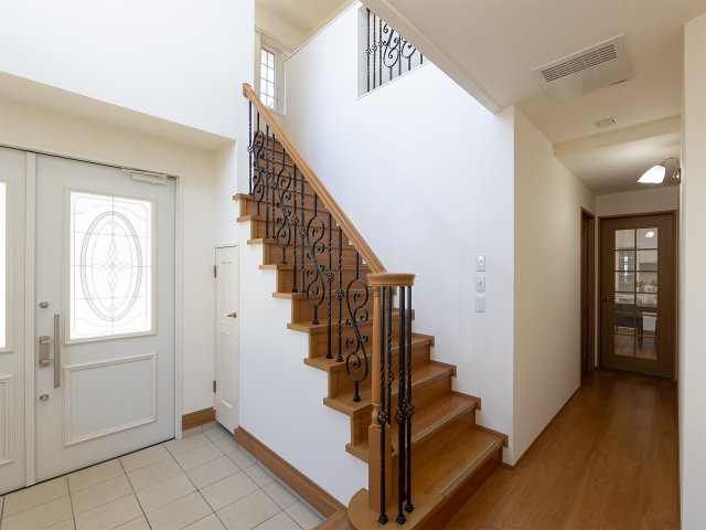 会津若松市天寧寺の玄関|上部から光が降り注ぐ開放的なエントランス。アイアン調の階段手すりが優雅さを演出します。