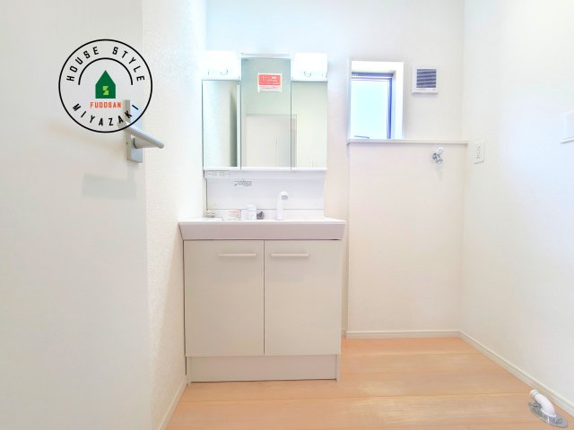 都城市早水町第1-2棟（1号棟）の内観：施工例|毎日使うものだから清潔な空間を保ちたい水回り。洗面にはそんな願いを解消させてくれる収納アイデアが満載です。三面鏡の裏側にはキャビネットが現れ小物から背の高い物まで収納できます。