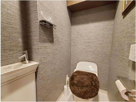 高知市北本町2丁目クレアホームズ高知駅前　中古マンションのトイレ|アクセントクロスが映えるトイレ空間。来客時も安心、独立手洗い付きトイレ