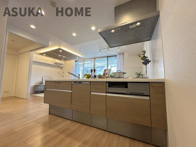 アトラス上大岡ヒルズのキッチン|開放感のあるすっきりとしたキッチンで、木目調のシステムキッチンがリビング空間に溶け込んでいます。