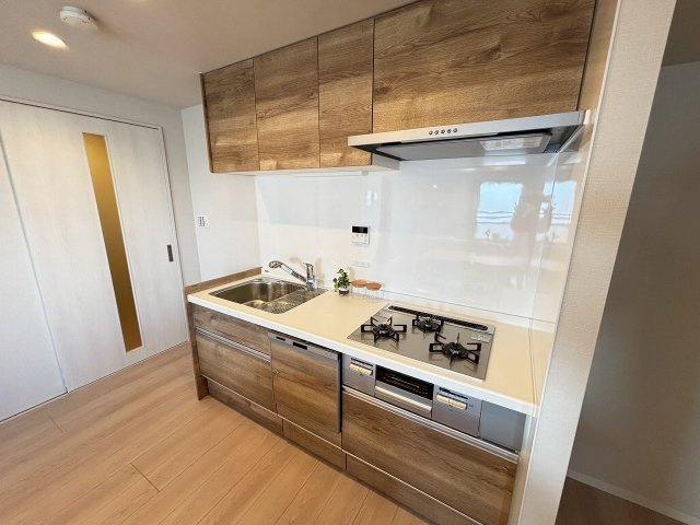 【キッチン】 | グローリオ高円寺 | 最新型システムキッチンは三口コンロに食器洗浄乾燥機能付き♪リビングとの一体感で落ち着きのある色合いで仕上げました。使い勝手も良く、日々の炊事を手助け致します！