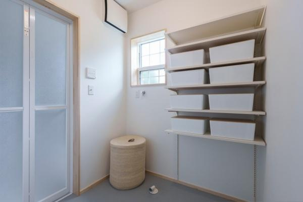 三佐　BERSAの独立洗面台|シンプルなデザインの洗面所で使いやすいオープン収納棚が配置されています。明るい窓から自然光が差し込み清潔感のある空間です。収納力のある棚が生活をサポートします。