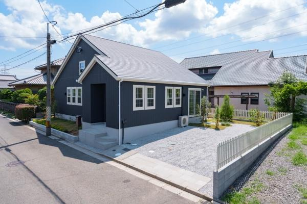 三佐　BERSAの外観|落ち着いた色合いの外観が印象的です。シンプルながらも洗練されたフォルムが魅力です。道路からのアクセスも良好な配置となっています。前面には整った植栽スペースが設けられています。